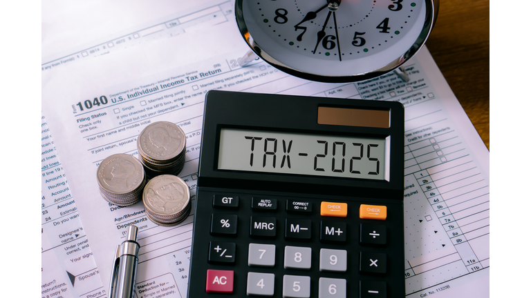 Word Tax 2025 on the calculator on documents.Income Statement. paying the tax rate. Taxation, taxes burden, savings and New Year Resolution.Business and tax concept.