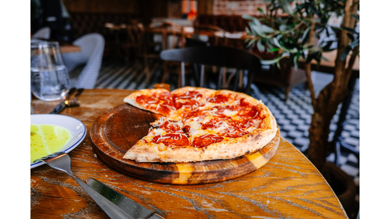 Pepperoni pizza. Sliced pizza on a table in a pizzeria.
