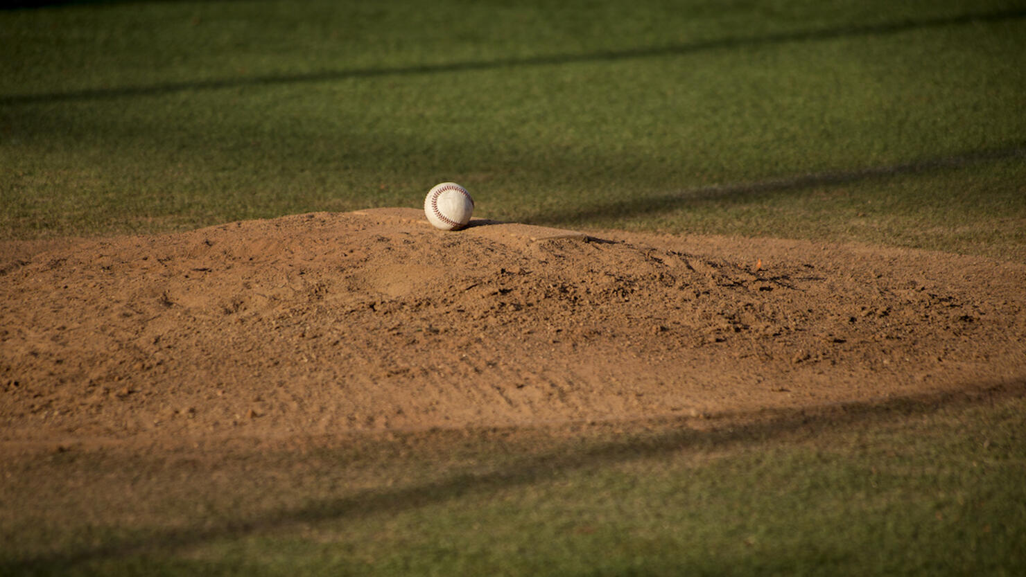 Baseball ball on sand mound on baseball field