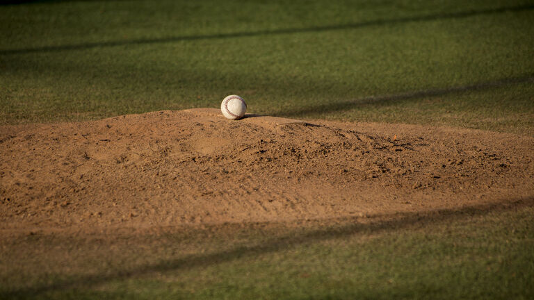 Baseball ball on sand mound on baseball field