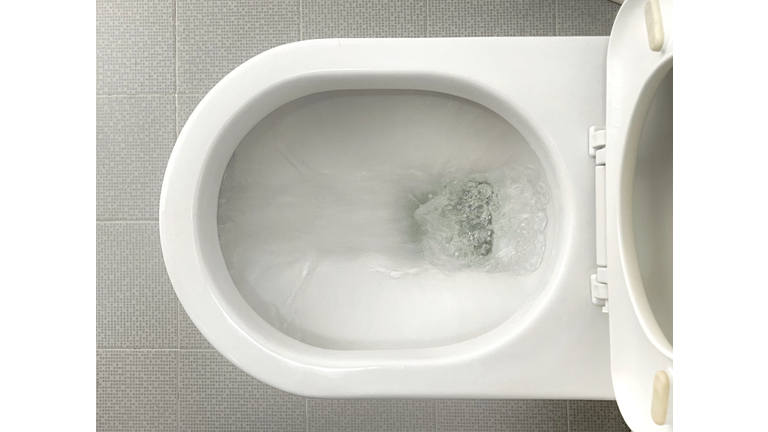 Water flushes down toilet bowl