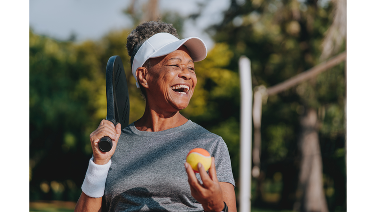 Portrait senior woman beach tennis