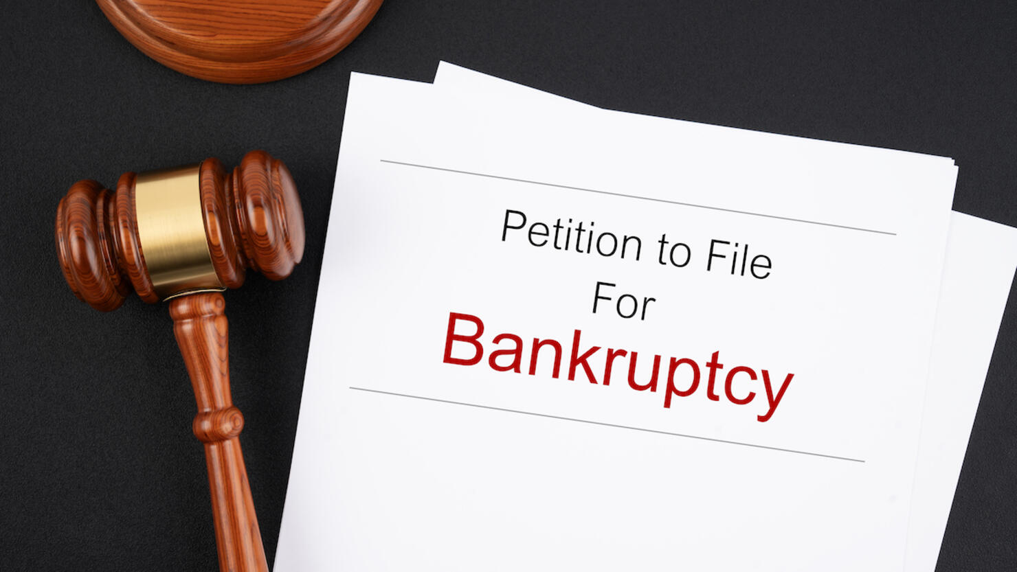 Bankruptcy document with wooden judge gavel on black table, Business concepts.