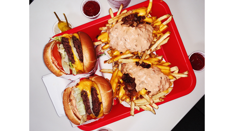 Double cheeseburgers and cheese fries on a tray in fast food joint