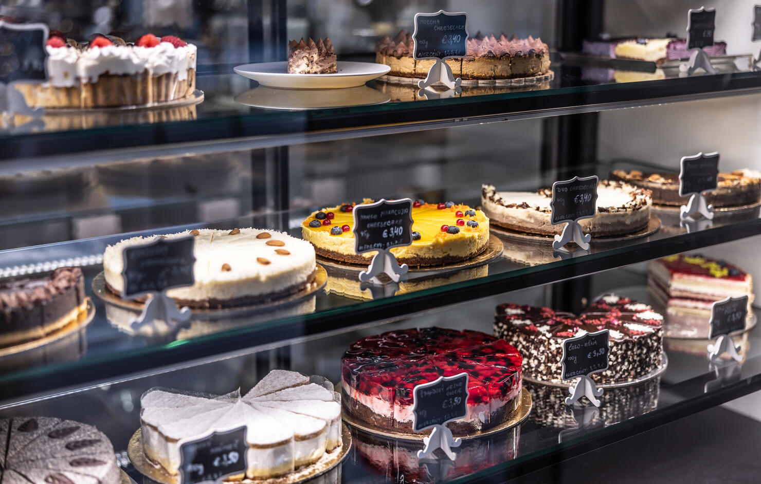 Cheesecakes, cakes and pies, in the window of a pastry shop and cafe.