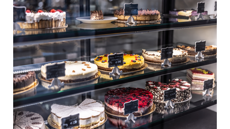 Cheesecakes, cakes and pies, in the window of a pastry shop and cafe.