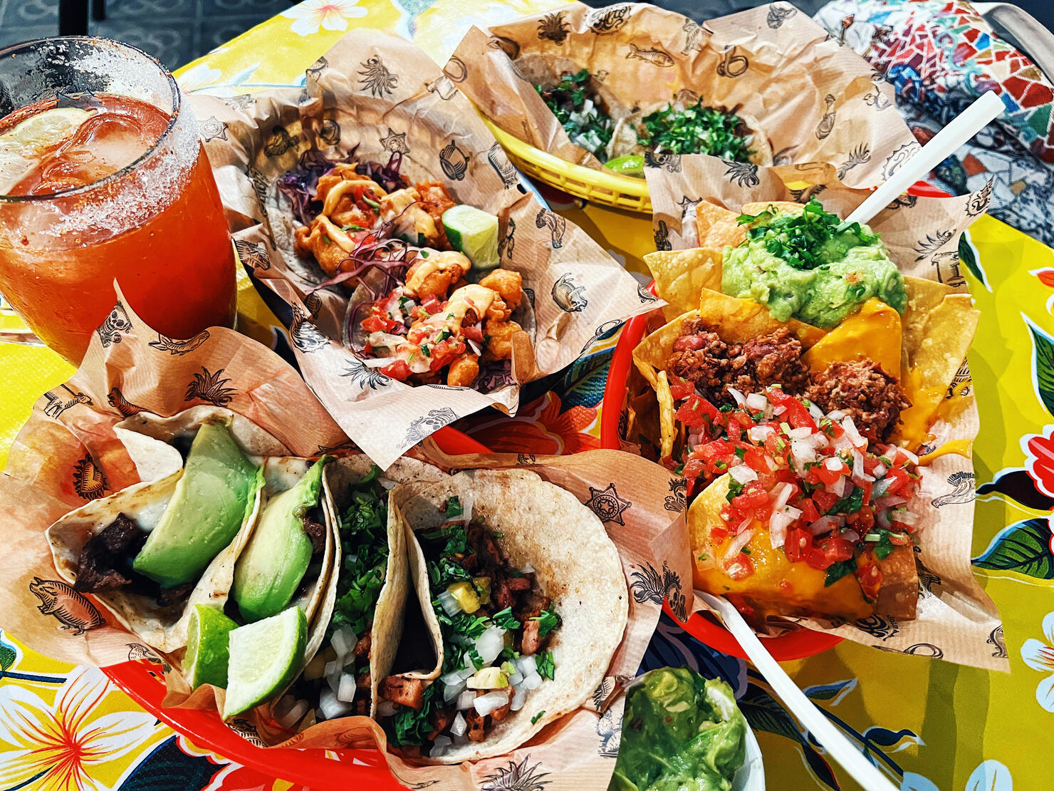 Dinner in Mexican restaurant with tacos, nachos, guacamole and michelada beer