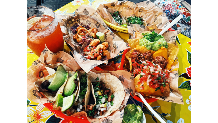 Dinner in Mexican restaurant with tacos, nachos, guacamole and michelada beer