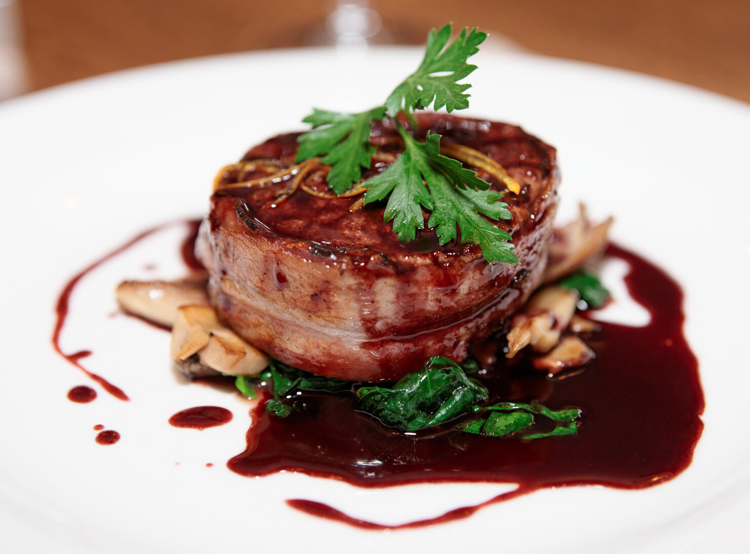 Tenderloin steak wrapped in bacon with red sauce and garlic