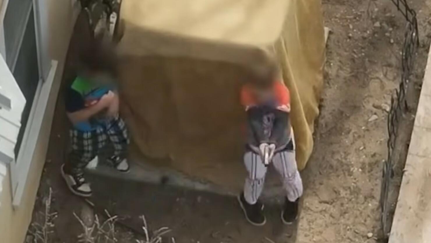 Two young boys play with loaded gun