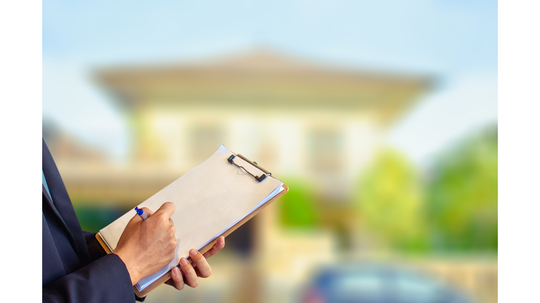 Man business salesman Sell house with computer On house and tree blurry background.For home business contracting or agreement and home warranty image