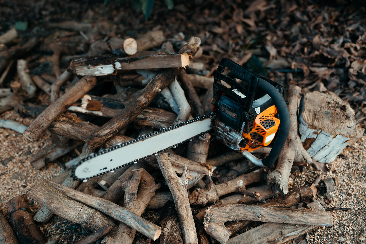A chainsaw over a mount of firewood