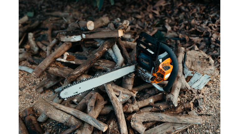 A chainsaw over a mount of firewood