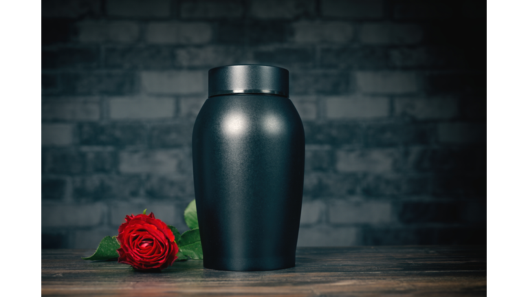 Funeral mourning urn next to a rose flower.