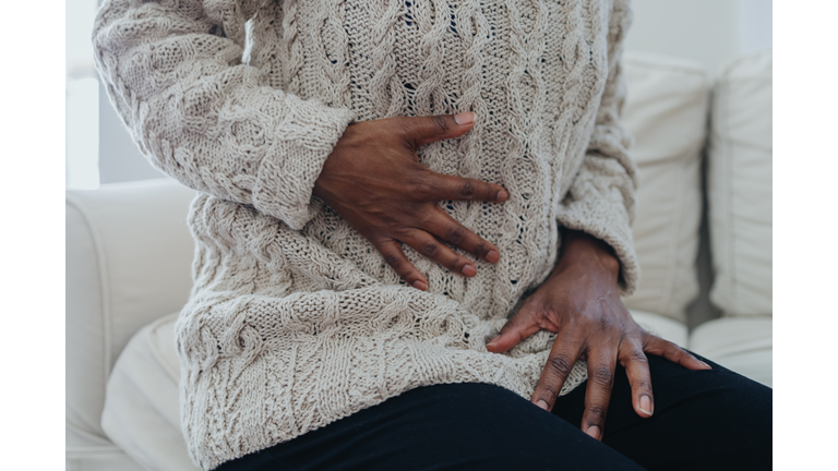 Woman Holds Abdomen in Pain