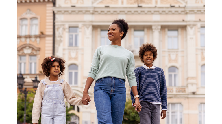 Single African American Mother With Her Children in City Center – Family Bond Concept