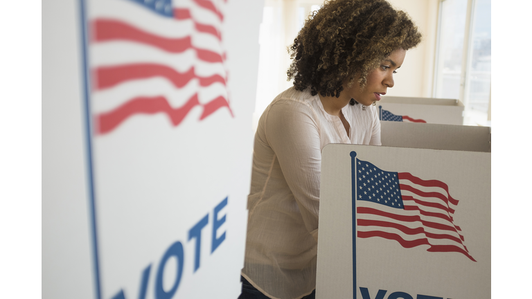 Young woman preparing voting booth