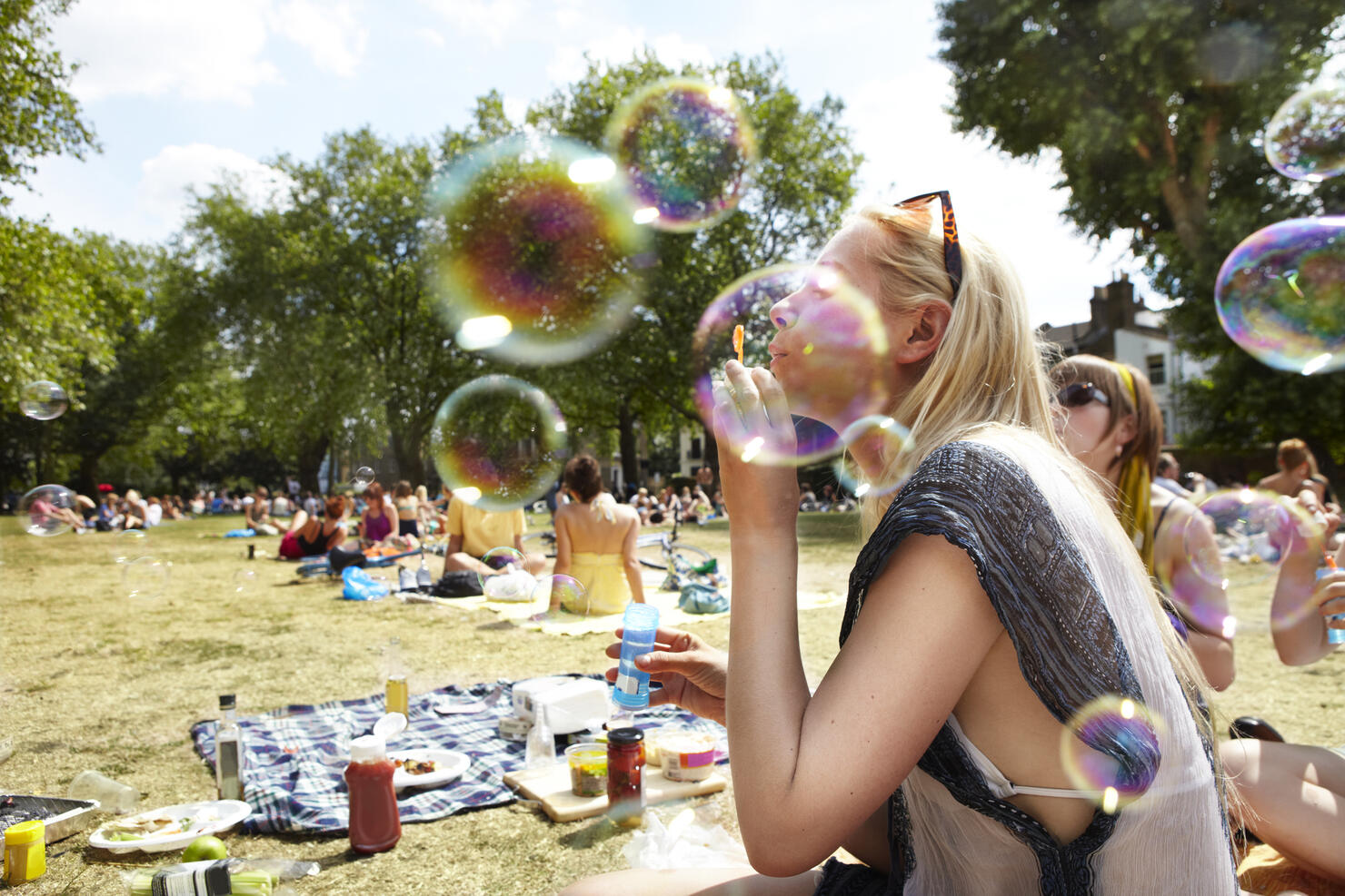 Friends blowing bubbles in the park