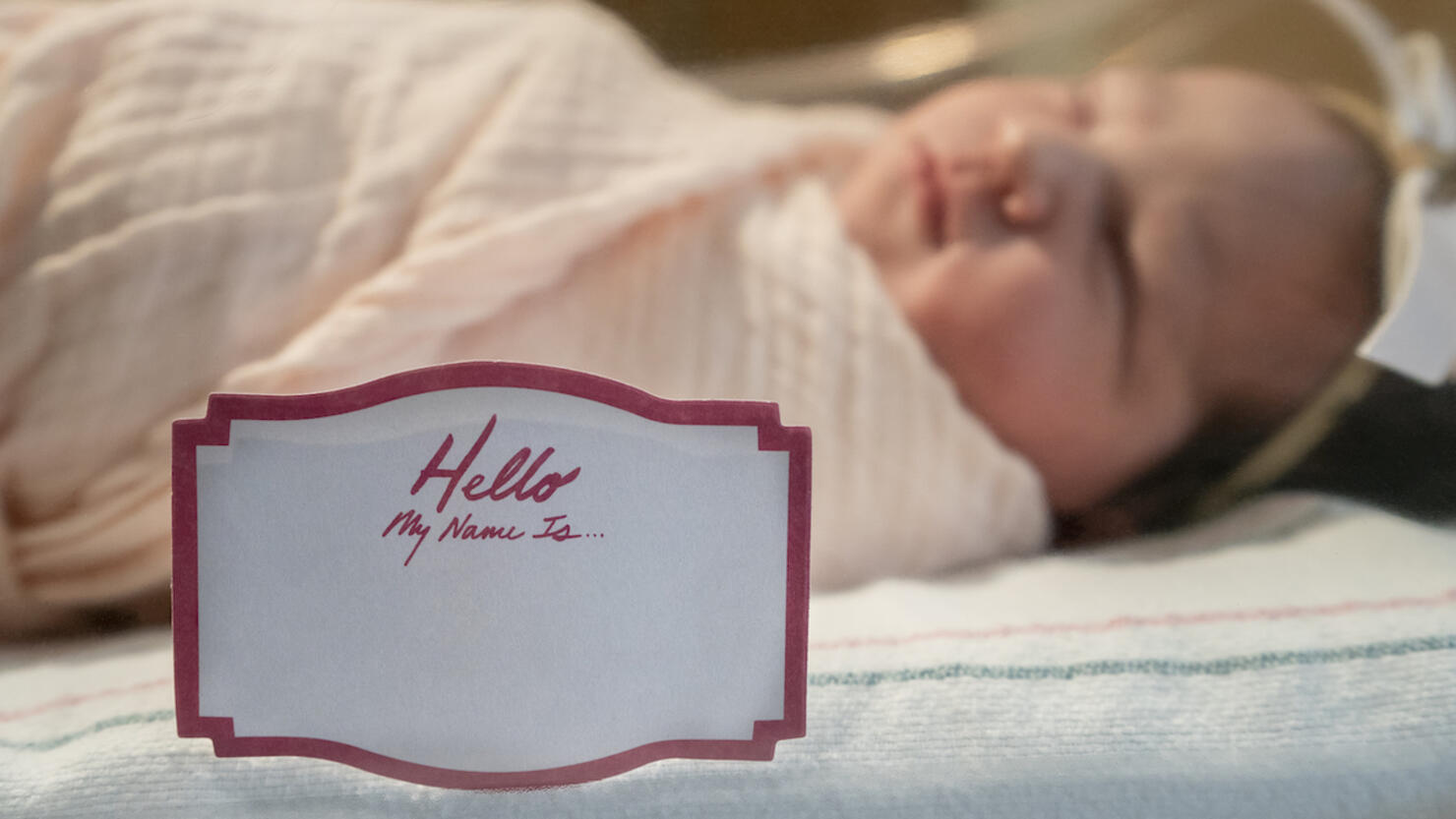 newborn baby girl with tag my name is