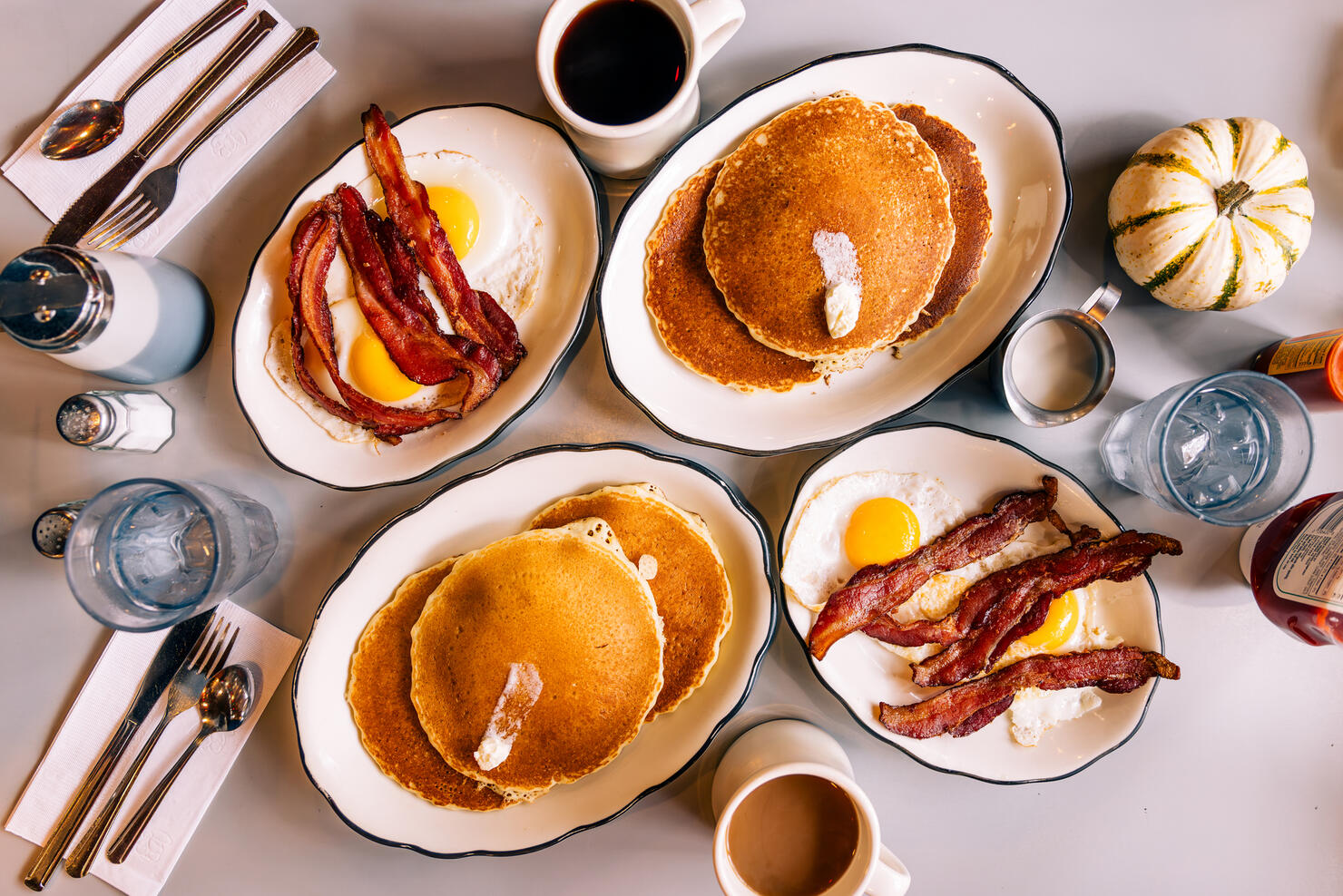Pancakes with fried eggs and bacon served for breakfast in a diner, high angle view