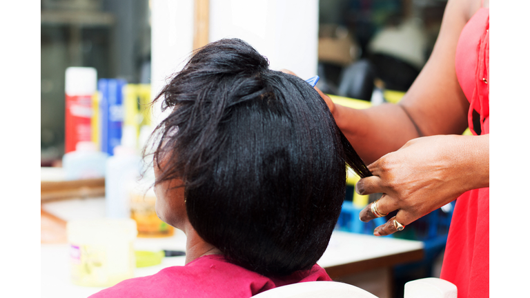 The hairdresser creates a model of hair on the head of her clent.