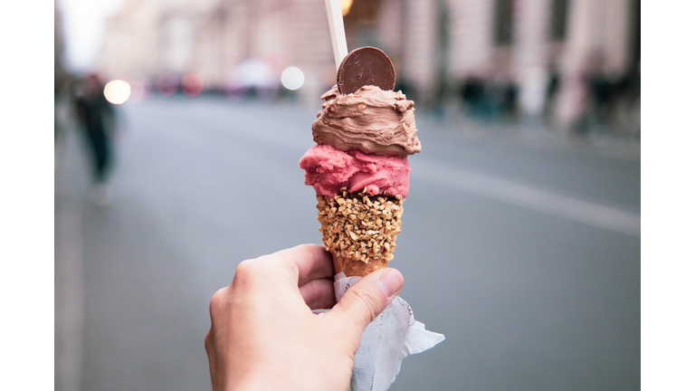 Trying tasty ice cream with levels in Rome during travel vacations.