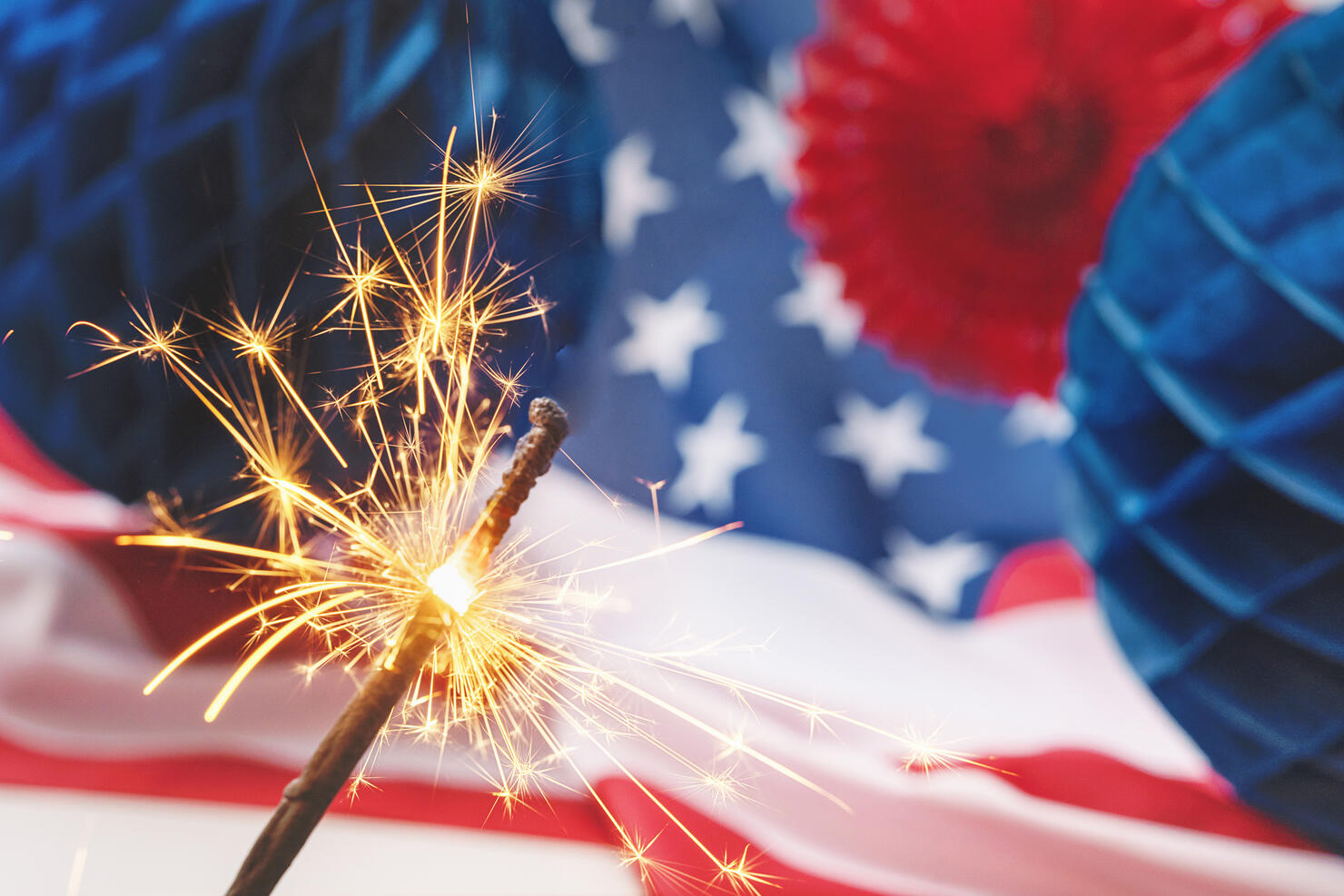 US flag with 4th of July paper fan and fireworks