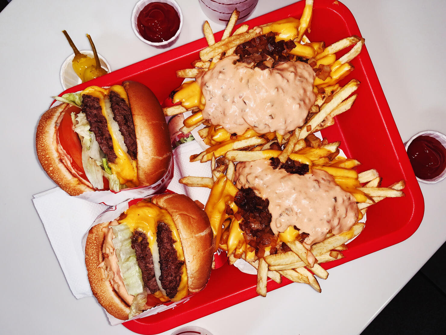 Double cheeseburgers and cheese fries on a tray in fast food joint
