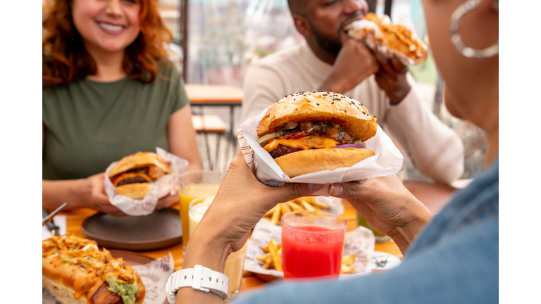 Close-up on a burger while people eat at a fast food restaurant