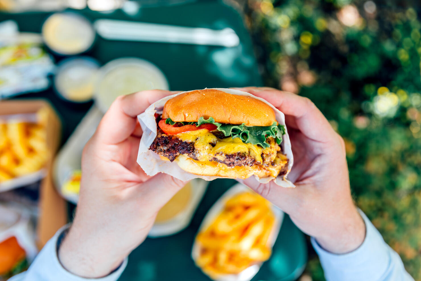 Man eating juicy cheeseburger, personal perspective view