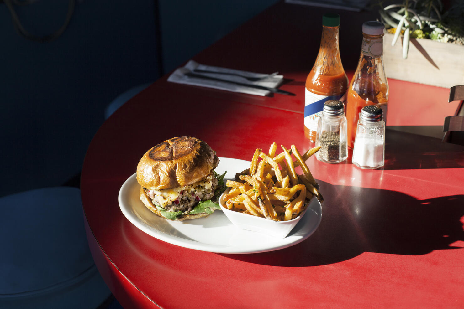 Burger and French fries served in plate on table