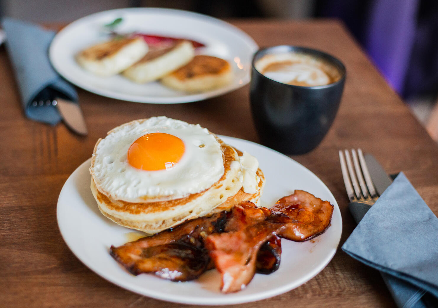 Tasty breakfast with pancakes, fried egg, coffee and bacon