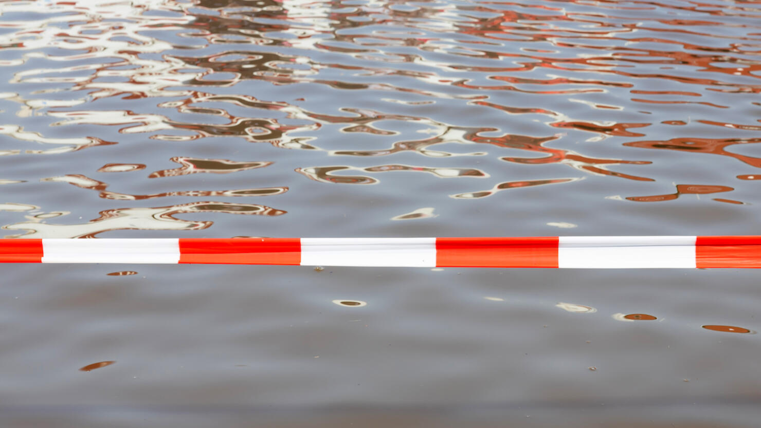 Barrier tape at a flooded road