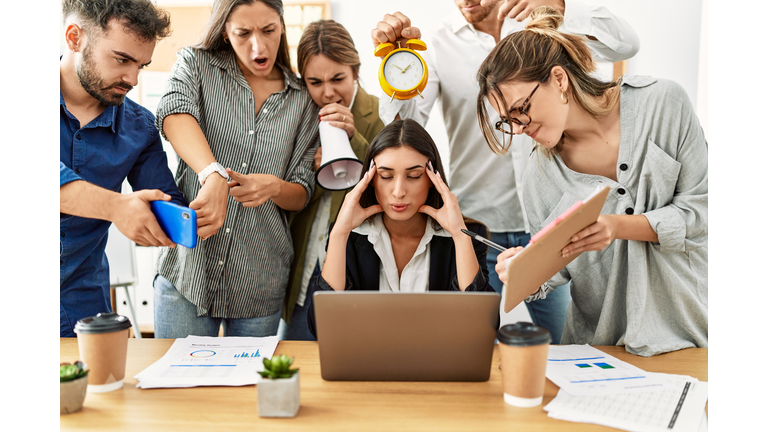 Group of business workers screaming to stressed partner at the office.