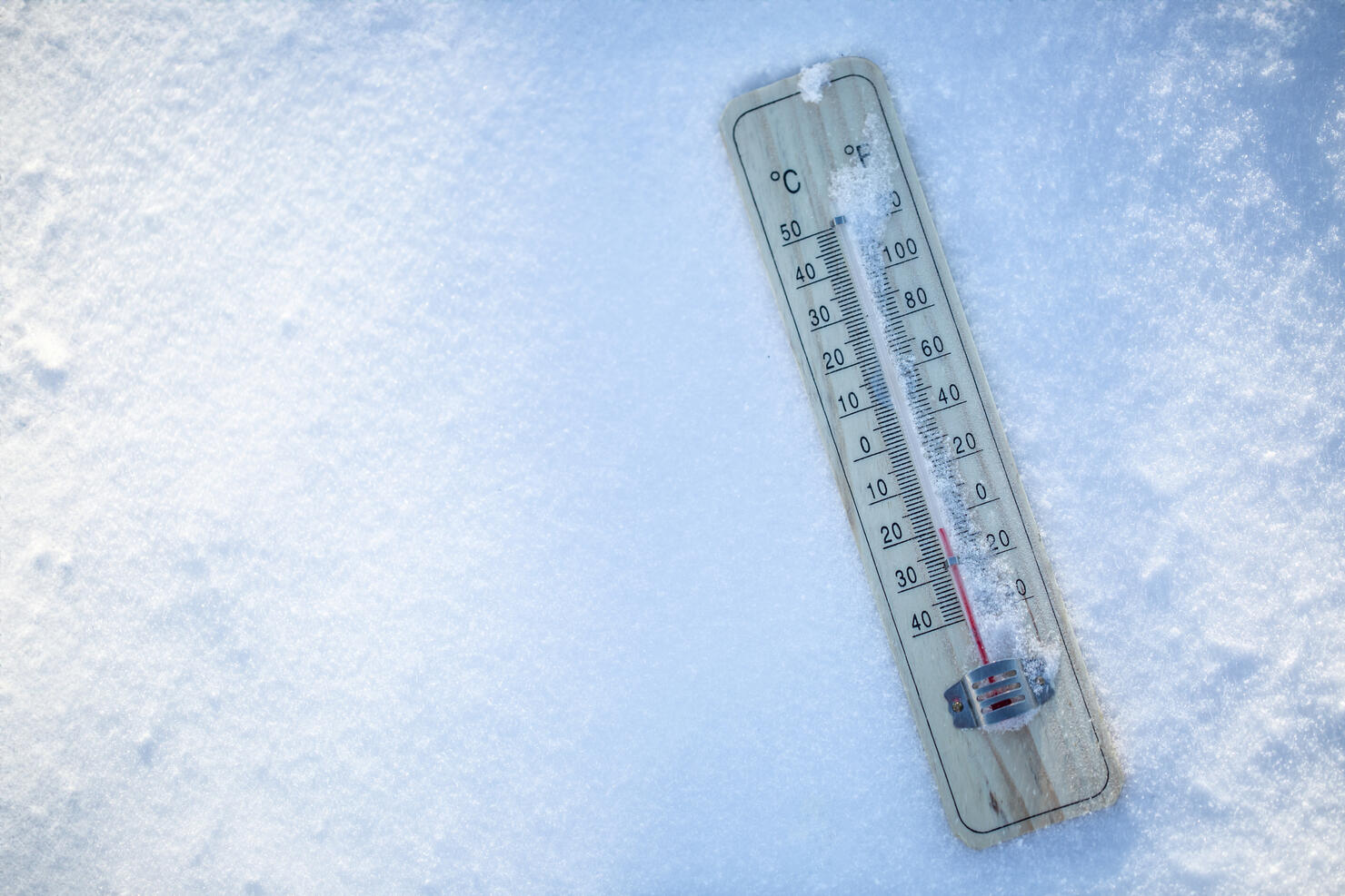 The thermometer on the snow shows low temperatures well below zero. Extreme winter freezing weather.