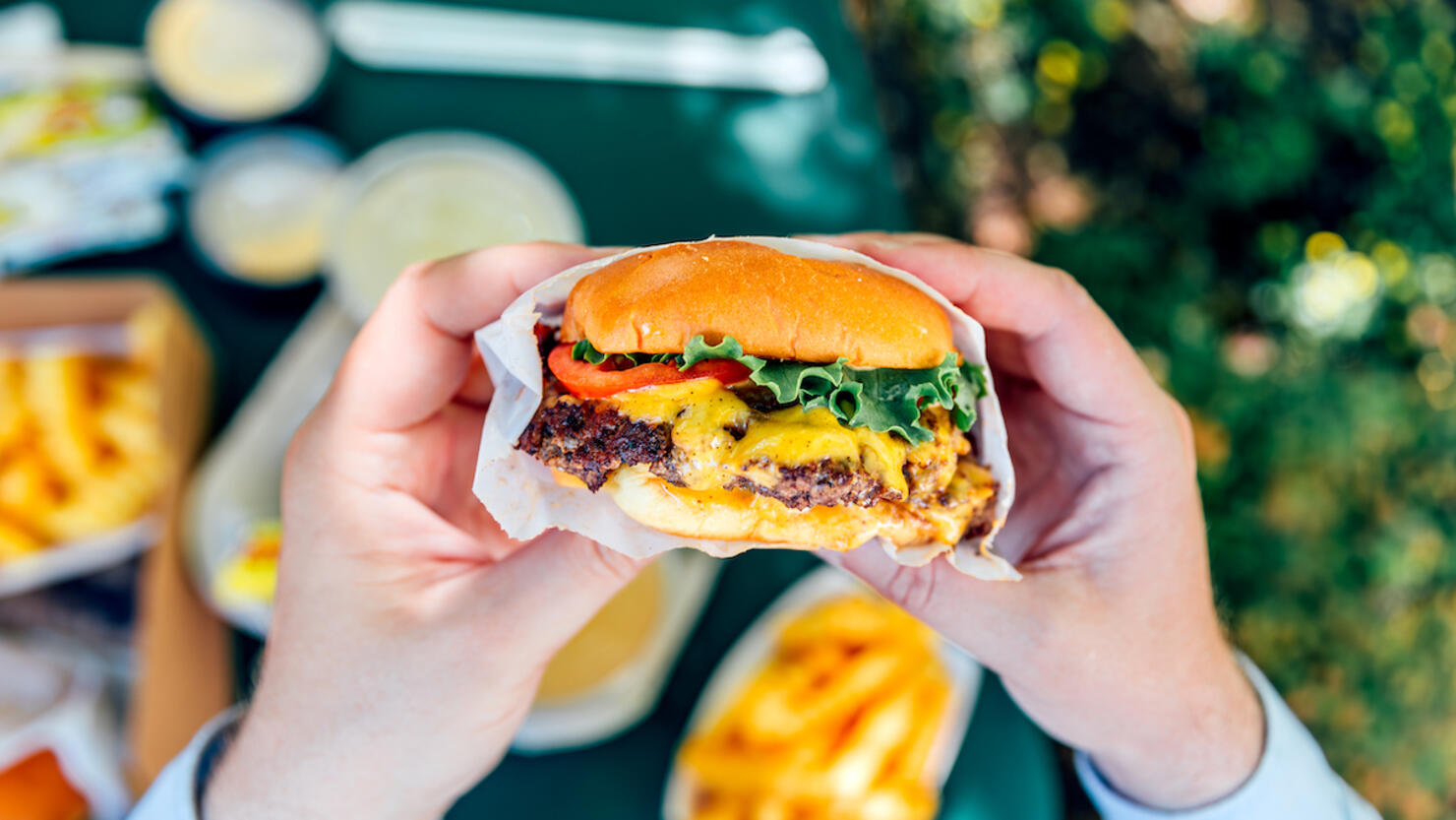 Man eating juicy cheeseburger, personal perspective view