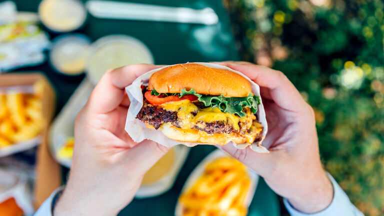 Man eating juicy cheeseburger, personal perspective view