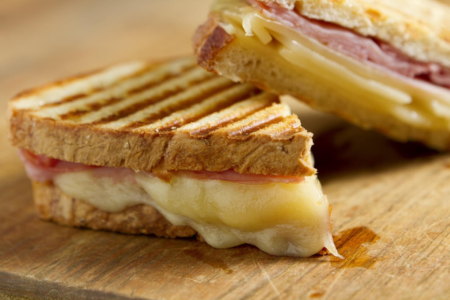 Cheese and ham panini sandwiches on a wooden board