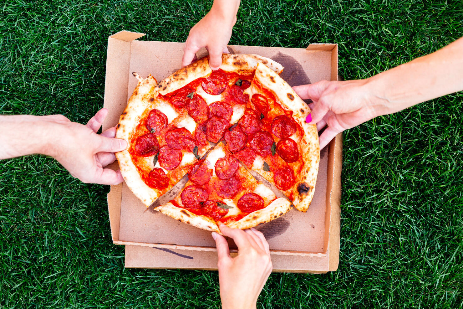 Family of four sharing pizza, directly above view