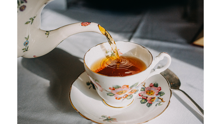 Vintage Teapot Pouring Tea in Tea cup