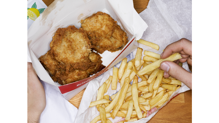 Men eating fast food, fries chicken and fries