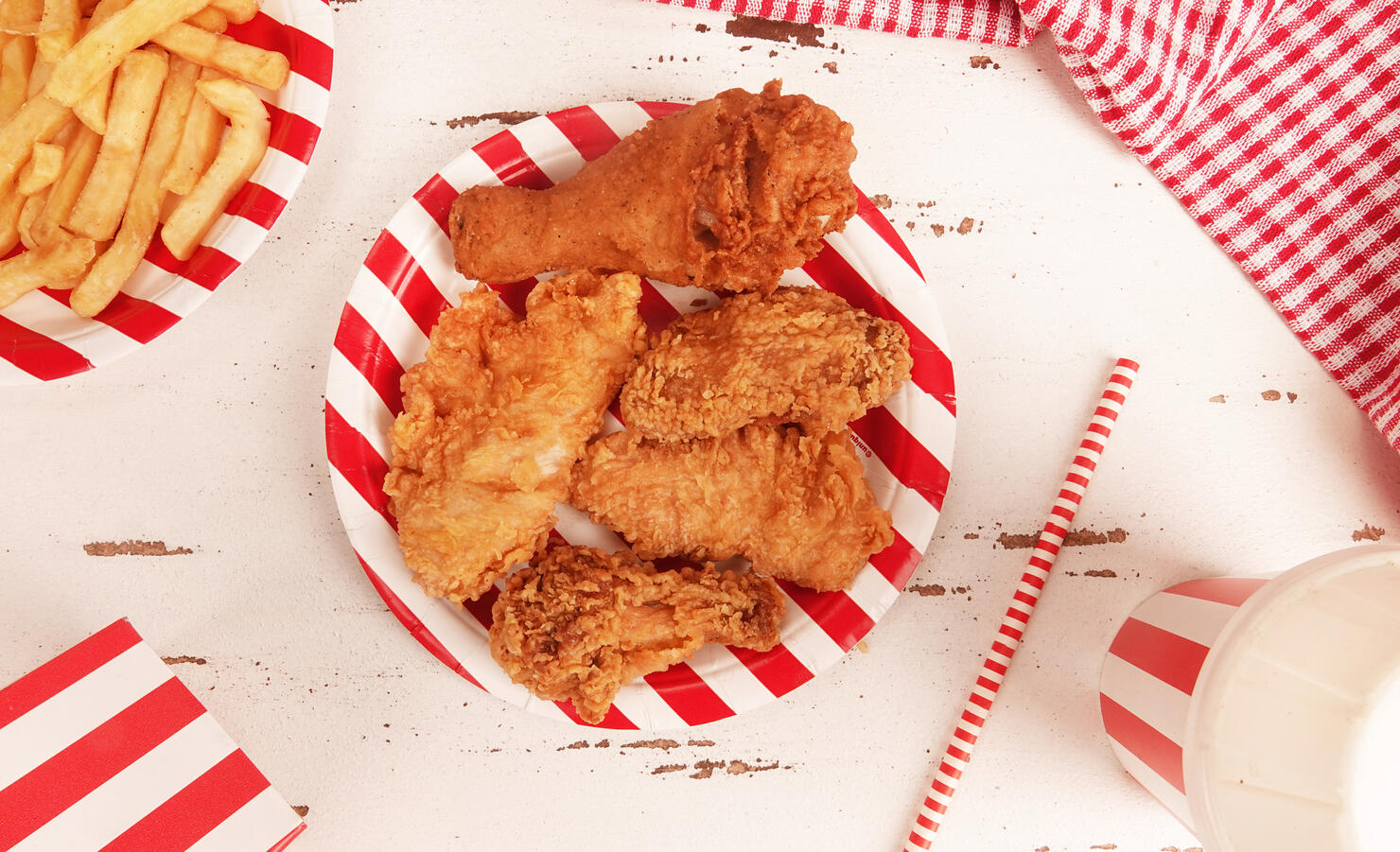 Perfect fried chicken pieces fast food on red white striped plate