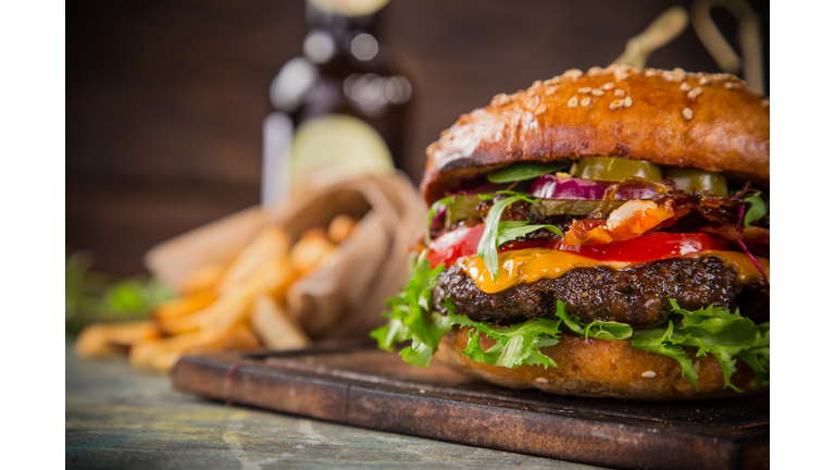 Tasty burgers on wooden table