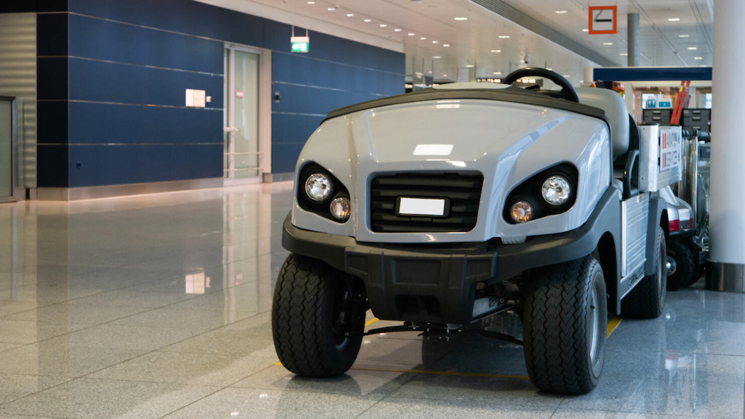 Luggage and disabled people carrying vehicle inside international airport terminal parked no people