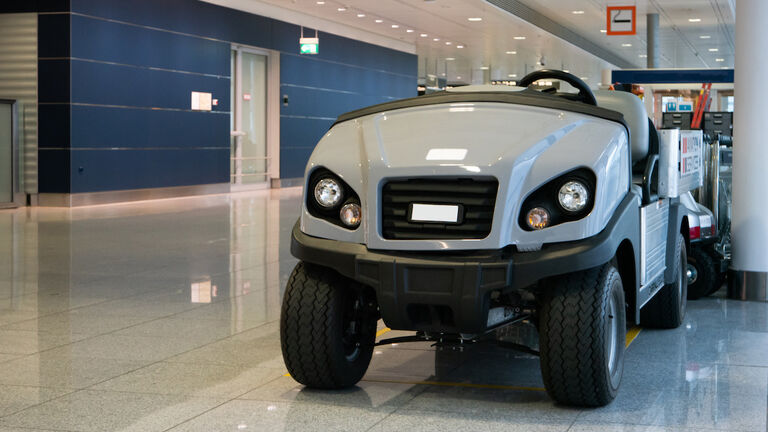Luggage and disabled people carrying vehicle inside international airport terminal parked no people