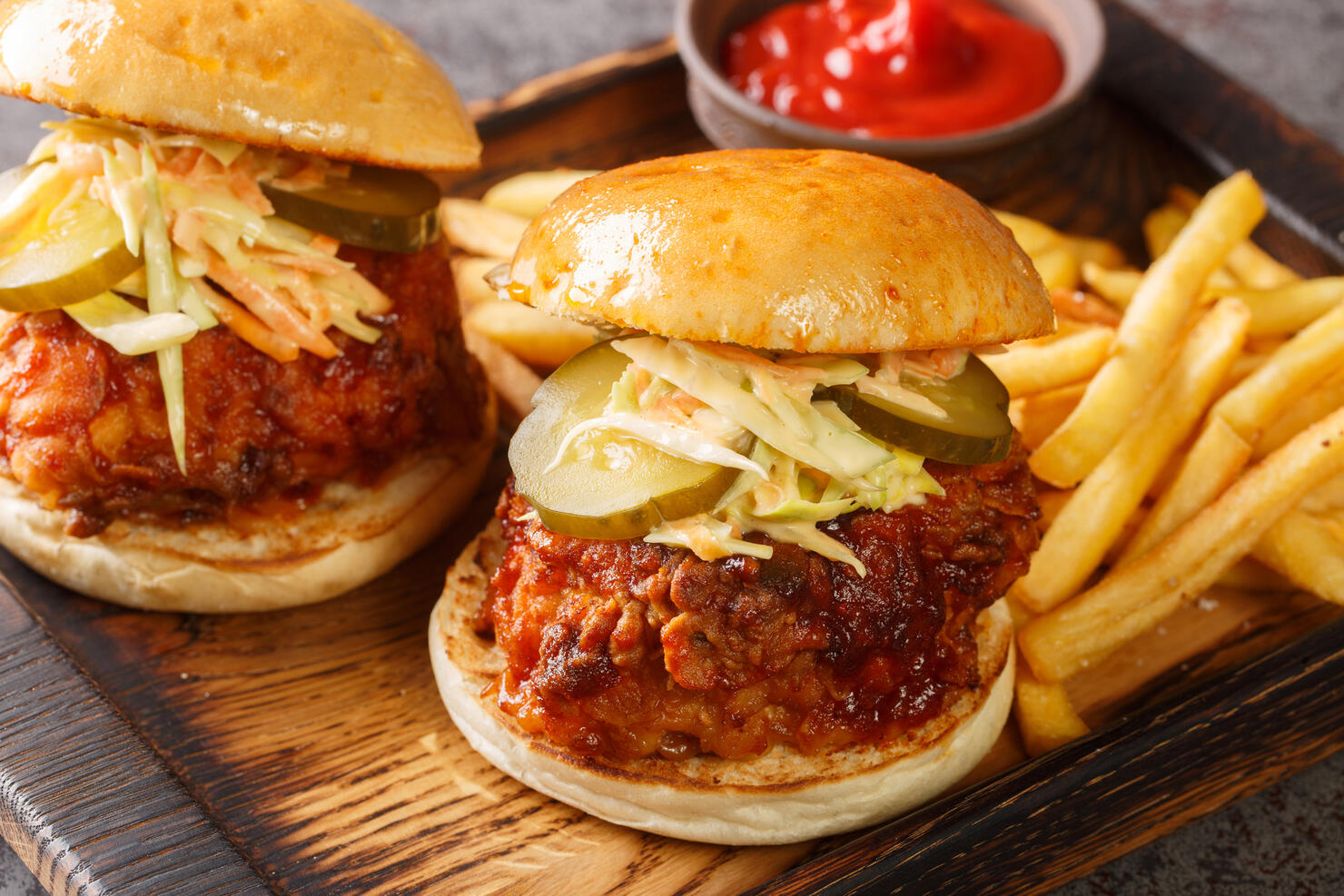 Spicy southern style fried chicken sandwich with coleslaw and pickles closeup on the tray. Horizontal