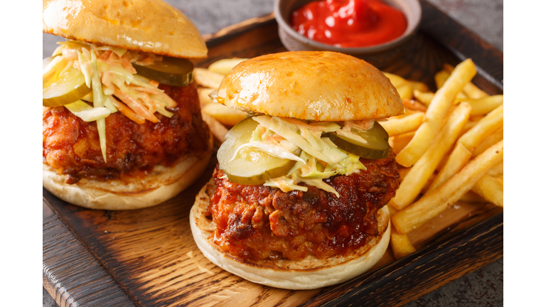 Spicy southern style fried chicken sandwich with coleslaw and pickles closeup on the tray. Horizontal