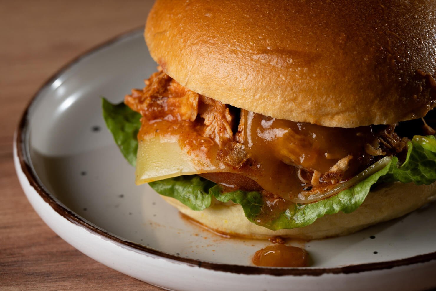 Delicious chicken burger with lettuce, cheese and sauce on a plate