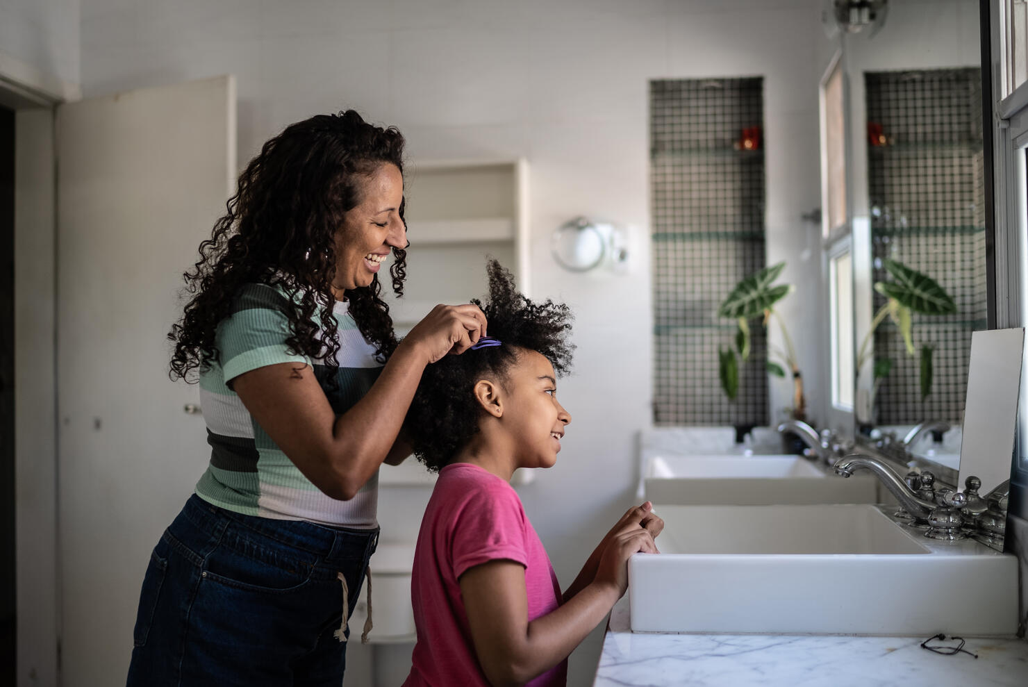 Mother combing daughter's hair at home