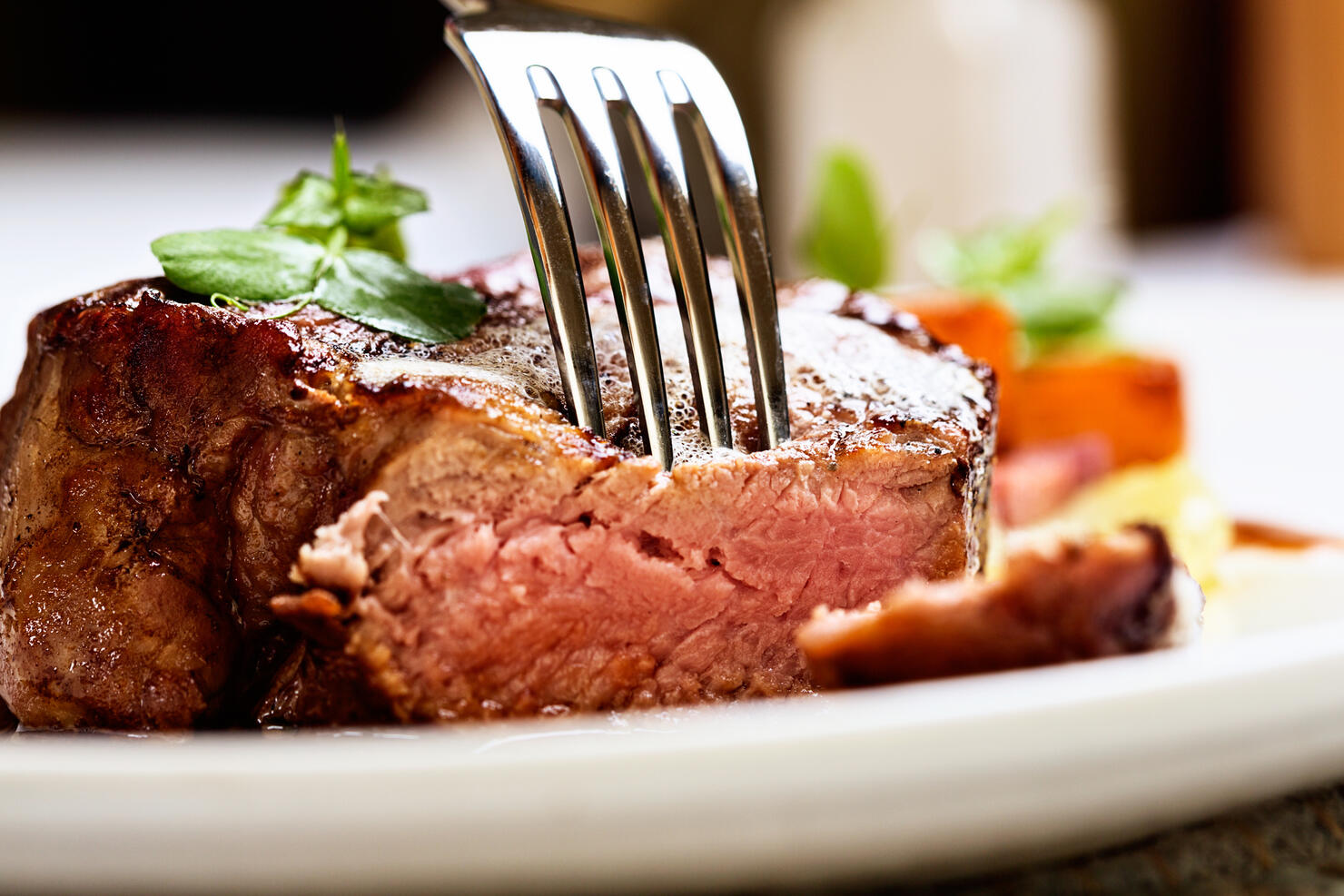 Tender and juicy, a fork pierces grilled beef fillet